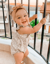 Baby girl is wearing handmade knot head wrap for little girls from By Bella Boutique.
